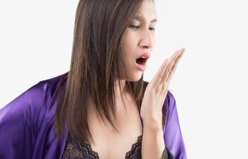 A woman checking her breath.